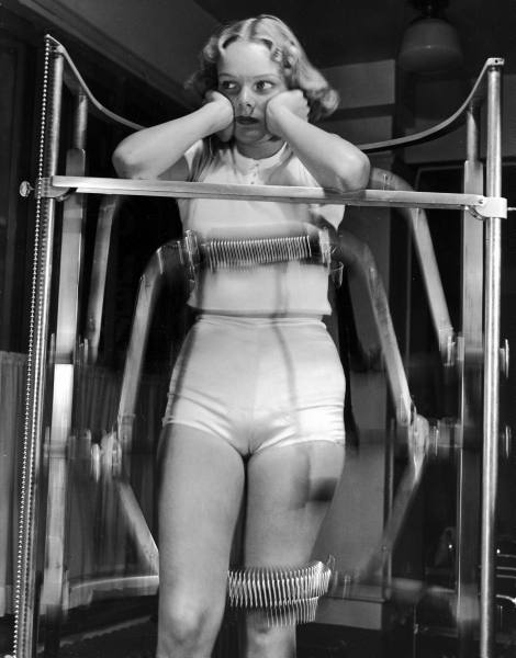 Model-Pat-Ogden-at-slenderizing-salon-enduring-the-rigors-of-the-Slendo-Massager-that-runs-rollers-up-and-down-to-electrically-rub-away-stomach-hips-and-thighs.